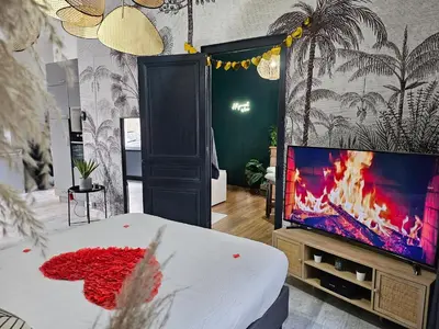 Télévision ou salle de divertissement dans l'établissement Suite Passion - Jacuzzi privé - Table massage