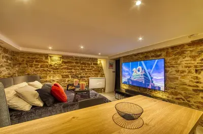 Télévision ou salle de divertissement dans l'établissement Movie Room Immersion unique et atmosphère cosy assurée - wifi inclus