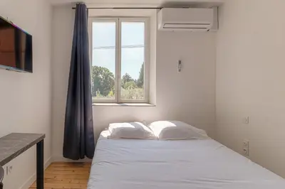 Un ou plusieurs lits dans un hébergement de l'établissement Le Berlin - Les appartements de l'olivier