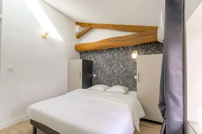 Un ou plusieurs lits dans un hébergement de l'établissement Le Nuremberg - Les appartements de l'olivier