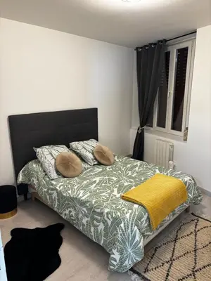 Un ou plusieurs lits dans un hébergement de l'établissement Charmant appartement 2 chambres