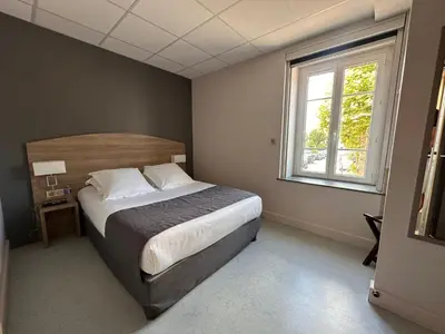 Un ou plusieurs lits dans un hébergement de l'établissement Hôtel des Lys