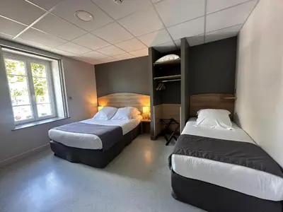 Un ou plusieurs lits dans un hébergement de l'établissement Hôtel des Lys