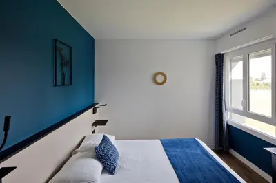 Un ou plusieurs lits dans un hébergement de l'établissement Hôtel Le Riccoty