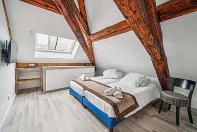 Un ou plusieurs lits dans un hébergement de l'établissement Appartement Chaleureux et Moderne sous les toits du Château 8pers