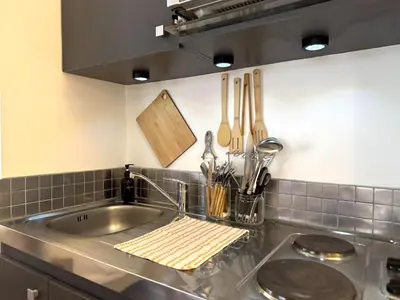 Cuisine ou kitchenette dans l'établissement Le Mur de pierre, BNB Conciergerie