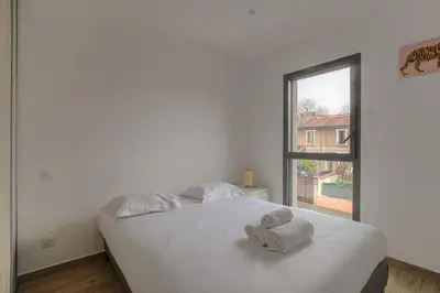 Un ou plusieurs lits dans un hébergement de l'établissement Maison Chaleureuse avec jardin