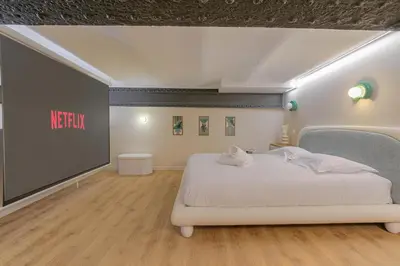 Un ou plusieurs lits dans un hébergement de l'établissement Le Loft des Lumières Spa Privatif & Nuit Cinéma