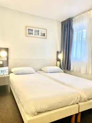 Un ou plusieurs lits dans un hébergement de l'établissement Brit Hotel Lyon Nord Dardilly