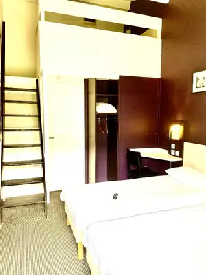 Un ou plusieurs lits dans un hébergement de l'établissement Brit Hotel Lyon Nord Dardilly
