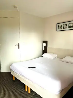 Un ou plusieurs lits dans un hébergement de l'établissement Brit Hotel Lyon Nord Dardilly
