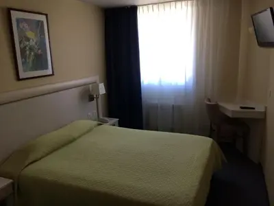 Un ou plusieurs lits dans un hébergement de l'établissement Hotel Elysée