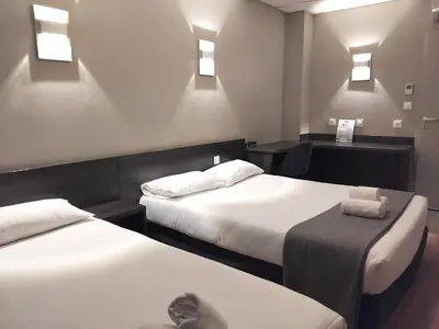 Un ou plusieurs lits dans un hébergement de l'établissement Hôtel Le Bratoria, anciennement Le Saint Vincent