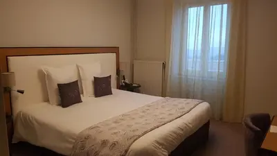 Un ou plusieurs lits dans un hébergement de l'établissement Logis Hôtel Le Tisseur des Saveurs