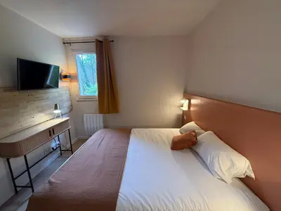 Un ou plusieurs lits dans un hébergement de l'établissement Logis Hôtel La Cascade - Lyon Nord