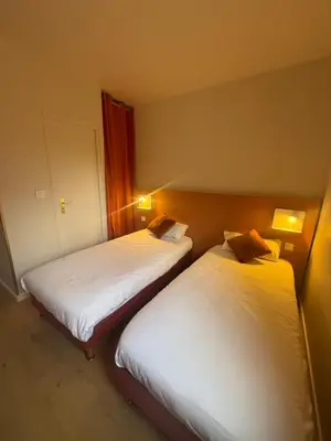 Un ou plusieurs lits dans un hébergement de l'établissement Logis Hôtel La Cascade - Lyon Nord