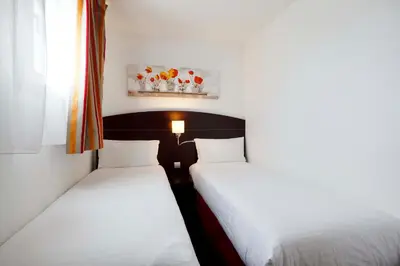 Un ou plusieurs lits dans un hébergement de l'établissement Kyriad Lyon Sud - Saint Genis Laval