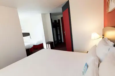 Un ou plusieurs lits dans un hébergement de l'établissement Kyriad Lyon Sud - Saint Genis Laval