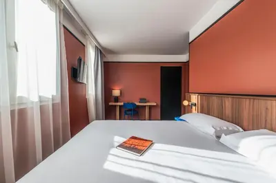 Un ou plusieurs lits dans un hébergement de l'établissement Hotel Le Lumière