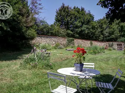 Jardin de l'établissement Gîte spacieux en campagne avec jacuzzi, sauna et jeux extérieurs - FR-1-496-52