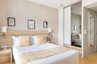 Un ou plusieurs lits dans un hébergement de l'établissement Appart hôtel Q7 Lodge Lyon 7
