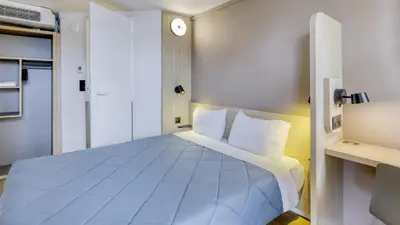 Un ou plusieurs lits dans un hébergement de l'établissement Premiere Classe Lyon Est Aeroport Saint Exupery
