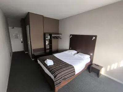 Un ou plusieurs lits dans un hébergement de l'établissement Adonis Lyon Est Hôtel Artys