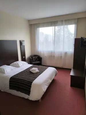 Un ou plusieurs lits dans un hébergement de l'établissement Adonis Lyon Est Hôtel Artys