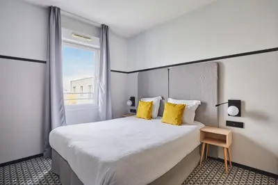 Un ou plusieurs lits dans un hébergement de l'établissement Appart'hôtel Odalys City - Bioparc Lyon Est