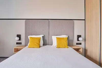 Un ou plusieurs lits dans un hébergement de l'établissement Appart'hôtel Odalys City - Bioparc Lyon Est