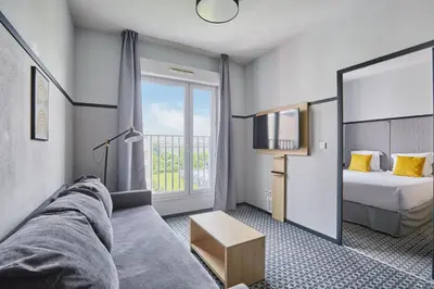 Un ou plusieurs lits dans un hébergement de l'établissement Appart'hôtel Odalys City - Bioparc Lyon Est