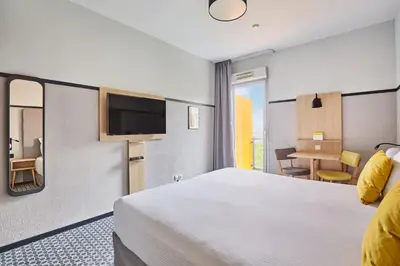 Un ou plusieurs lits dans un hébergement de l'établissement Appart'hôtel Odalys City - Bioparc Lyon Est