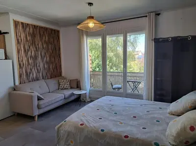 Un ou plusieurs lits dans un hébergement de l'établissement Studio dans maison avec jardin et balcon, au calme
