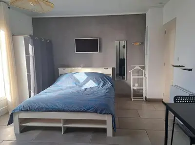 Un ou plusieurs lits dans un hébergement de l'établissement Studio dans maison avec jardin et balcon, au calme
