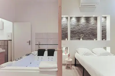 Un ou plusieurs lits dans un hébergement de l'établissement LES BULLES DE MONA - Lola - Spa - Clim