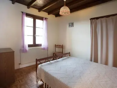 Un ou plusieurs lits dans un hébergement de l'établissement Gîte 65 m² avec cheminée, terrasse et jeux pour enfants - FR-1-496-283